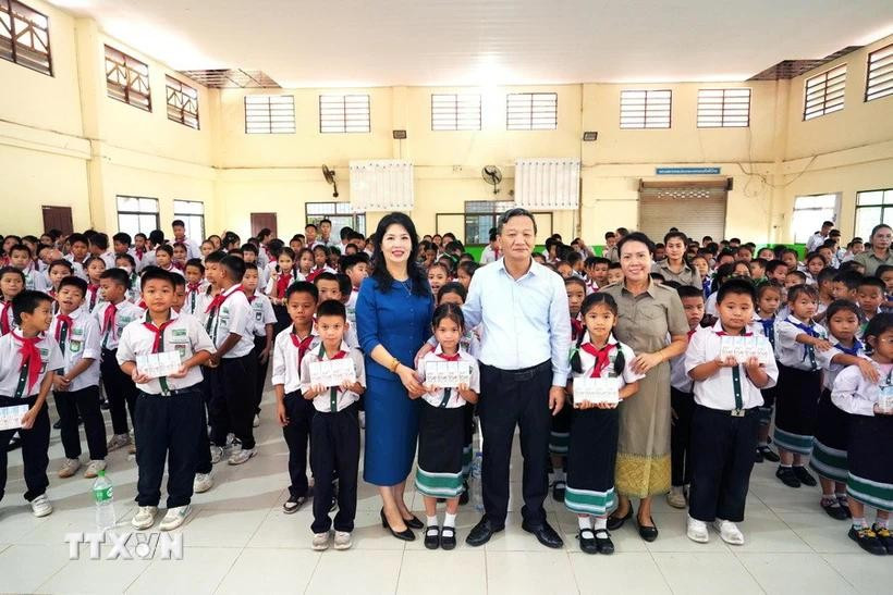 Ambassador Nguyen Minh Tam and his spouse pose for a photo with representatives of the Lao–Vietnamese Nguyen Du Bilingual School and its students. (Photo: VNA) 