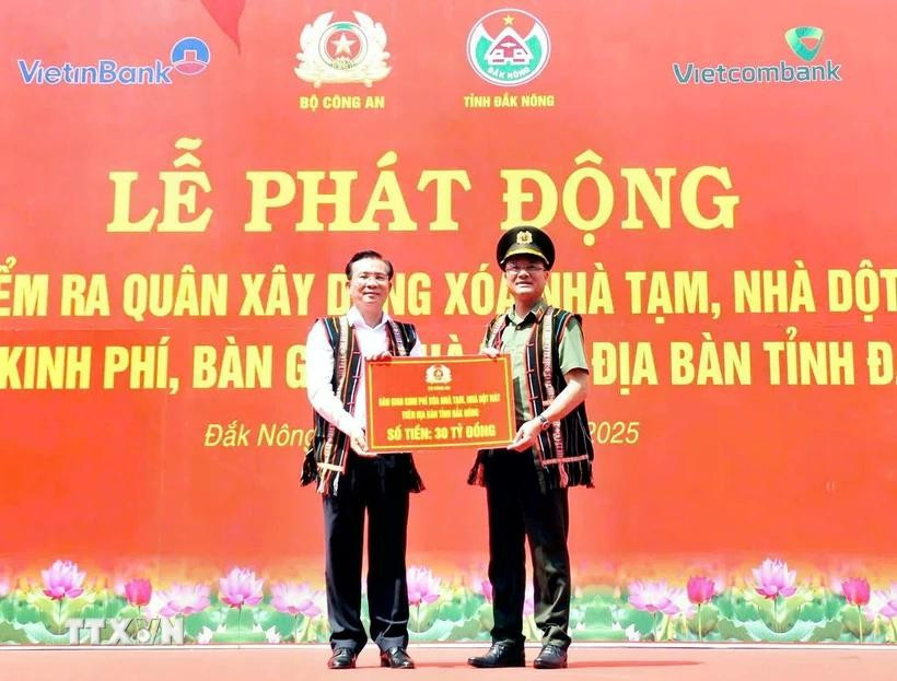 Lieutenant General Pham The Tung (R), member of the Party Central Public Security Committee and Deputy Minister of Public Security, presents the token for funding to eliminate 500 makeshift and dilapidated houses in Dak Nong province. (Photo: VNA) 