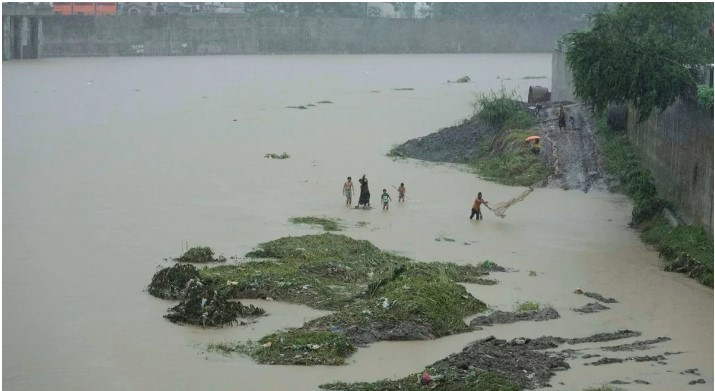 A man throws a fishing net along a swollen river following tropical storm Wipha fueled monsoon rains in Marikina, Philippines on July 22. (Photo: AP) 
