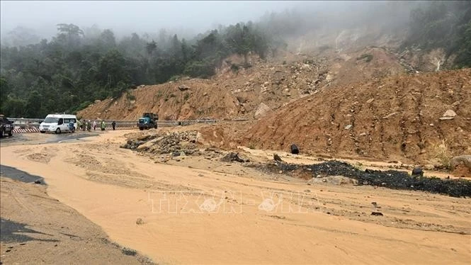 Soil and rocks from the uphill slope spill onto the road surface on Khanh Le pass. (Photo: VNA)