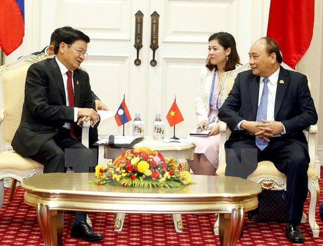 PM Nguyen Xuan Phuc meets Lao counterpart in Cambodia ảnh 1