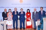 PM Pham Minh Chinh (centre) presents gifts to the Vietnamese community in Russia at the meeting in Moscow on late March 22 (local time). (Photo: VNA)