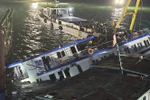 The capsized Vinh Xanh 58 tourist boat is salvaged and towed ashore early July 20 for further investigation. (Photo: VNA)