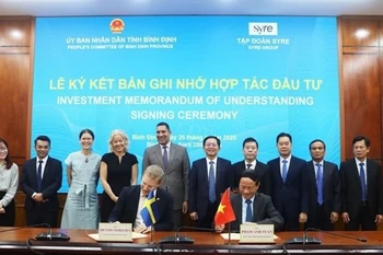 Chairman of the Binh Dinh provincial People’s Committee, Pham Anh Tuan (sitting, right), and the CEO of Syre Group sign a memorandum of understanding on investment cooperation on April 25. (Photo: nld)