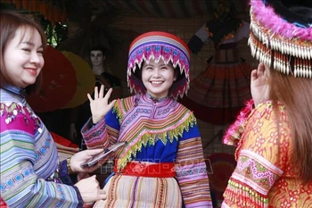 Traditional Hmong attire draws interest from tourists. (Photo: VNA)