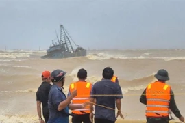 Rescue forces assist a fishing boat stranded at the breakwater of Cua Viet channel. (Photo courtesy of the Quang Tri Border Guard)