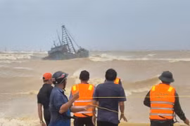 Rescue forces assist a fishing boat stranded at the breakwater of Cua Viet channel. (Photo courtesy of the Quang Tri Border Guard)