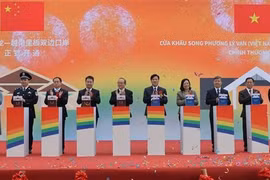 Leaders of Cao Bang province and Ha Lang district, along with representatives of Daxin county (China), press the button to inaugurate the Ly Van – Shuo Long border gate. (Photo: VNA)