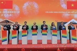 Leaders of Cao Bang province and Ha Lang district, along with representatives of Daxin county (China), press the button to inaugurate the Ly Van – Shuo Long border gate. (Photo: VNA)