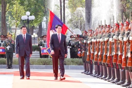 State President Luong Cuong (R) and General Secretary of the Lao People's Revolutionary Party (LPRP) Central Committee and President of Laos Thongloun Sisoulith review the guard of honour at the welcome ceremony on April 24 afternoon. (Photo: VNA)