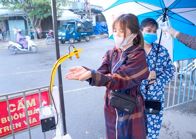 Da Nang volunteers make hands-free sanitiser dispensers ảnh 1