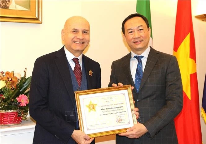 Vietnamese Ambassador to Italy Duong Hai Hung (right) hands over the "For the cause of Justice" insignia from the Vietnamese Ministry of Justice to former Italian Ambassador to Vietnam Antonio Alessandro. (Photo: VNA)