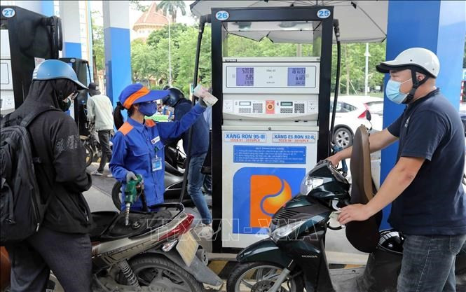 Motorcyclists have their vehicles refilled at a Petrolimex gas station. (Photo: VNA)