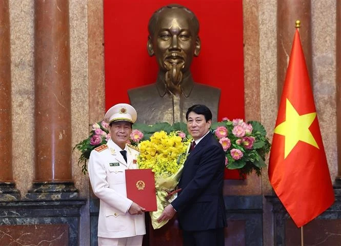 State President Luong Cuong hands over a decision on promoting Le Quoc Hung, member of the Party Central Committee and Deputy Minister of Public Security, from the rank of Lieutenant General to Senior Lieutenant General. (Phto: VNA)