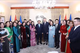 Prime Minister Pham Minh Chinh and his wife Le Thi Bich Tran in a group photo with staff of the Vietnamese Embassy in the Czech Republic on January 18 evening (local time). (Photo: VNA)