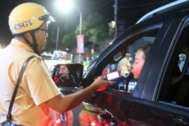 A police officer in Long Xuyen city, An Giang province, check alcohol levels of a driver. (Photo: VNA)