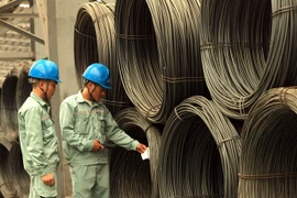 Technicians check rolled steel at the factory of the Vietnam Steel Corporation (VNSTEEL). (Photo: VNA)