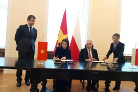 Deputy Minister of Foreign Affairs Nguyen Minh Hang (L) and Secretary of State at the Polish Foreign Affairs Władysław Teofil Bartoszewski sign the memorandum of understanding on strengthening bilateral diplomatic relations. (Photo: baochinhphu.vn)