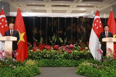 General Secretary To Lam and Singapore’s Prime Minister Lawrence Wong announce the upgrade of Vietnam-Singapore relations to a comprehensive strategic partnership (Singapore, March 12, 2025). (Photo: VNA)