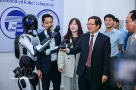 Deputy Prime Minister Ho Quoc Dung and delegates view a robot at the centralised practice centre of the University of Engineering and Technology, Vietnam National University, Hanoi. (Photo: VNA)