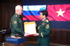 Deputy Prime Minister and Minister of National Defence Gen. Phan Van Giang (right) and Russian Defence Minister Andrey Belousov exchange souvenirs. (Photo: VNA)