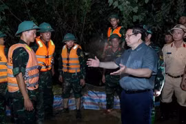 Prime Minister Pham Minh Chinh visits the forces working to reinforce the Cau River embankment, emphasising the need to ensure the dike’s safety. (Photo: VNA)