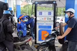Motorcyclists have their vehicles refilled at a Petrolimex gas station. (Photo: VNA)