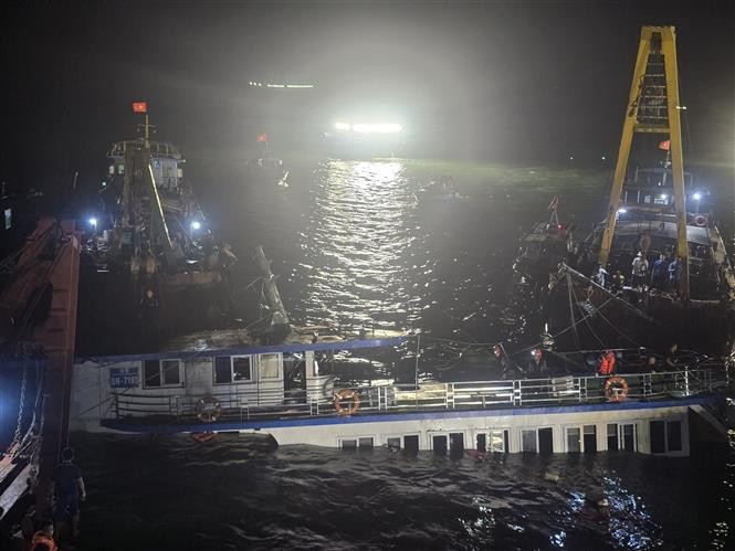 At 2:00 a.m. on July 20, rescue teams begin pumping water out of the capsized tourist boat before towing it ashore. (Photo: VNA)