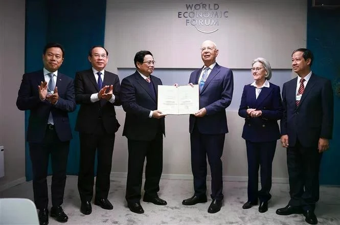 Prime Minister Pham Minh Chinh presents the honorary doctorate to Professor Klaus Schwab, Founder and Executive Chairman of the World Economic Forum. (Photo: VNA)