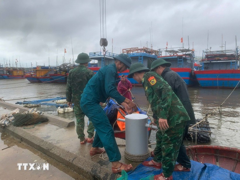 Border guard officers at Ky Ha Port Border Gate are assisting residents in securing their boats. (Photo: VNA)