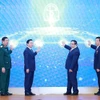 Prime Minister Pham Minh Chinh (third from right) and officials launch the Ministry of Construction’s new information technology systems at the conference on December 21. (Photo: VNA)