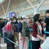Passengers wait to handle boarding procedures at Tan Son Nhat International Airport. (Photo: VNA)
