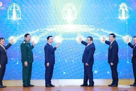 Prime Minister Pham Minh Chinh (third from right) and officials launch the Ministry of Construction’s new information technology systems at the conference on December 21. (Photo: VNA)