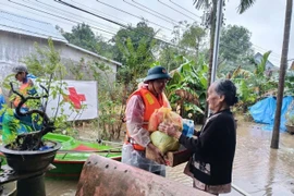A representative of the Vietnam Red Cross Society delivers relief to a flood-hit resident in Hue city. (Photo: VNA)