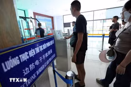 People handle electronic border guard procedures at the Lao Cai International Border Gate, which is among the newly added entry points for e-visa holders. (Photo: VNA)