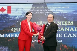 Ho Xuan Lam (right), Vice President and General Secretary of the HCM City Union of Friendship Organisations, presents flowers to congratulate Canadian Consul General Annie Dube at the event on July 2. (Photo: VNA)