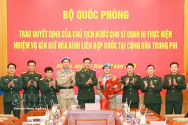 Officials at the ceremony presenting the decisions to Lieutenant Colonel Nguyen Hoang Long (fourth from right), who will serve at the UN Multidimensional Integrated Stabilisation Mission in the Central African Republic (MINUSCA) (Photo: VNA)