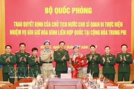 Officials at the ceremony presenting the decisions to Lieutenant Colonel Nguyen Hoang Long (fourth from right), who will serve at the UN Multidimensional Integrated Stabilisation Mission in the Central African Republic (MINUSCA) (Photo: VNA)