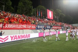 Vietnamese footballers celebrate the win at their ASEAN Cup first semi-final against Singapore on December 26 night. (Photo: VNA)