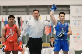 Wushu athlete Nguyen Thi Thu Thuy (blue) wins the gold medal in the women’s 60kg sanda final on December 15. (Photo: VNA)