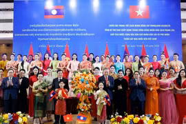 Party General Secretary To Lam and his spouse, together with Party General Secretary and President of Laos Thongloun Sisoulith and his spouse, present flowers to artists at the banquet. (Photo: VNA)