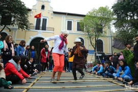 Foreign tourists enjoy a folk cultural activity in Hanoi (Photo: Nhan dan Newspaper)