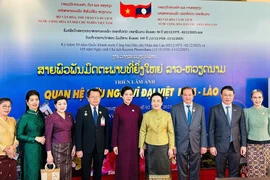 Madame Ngo Phuong Ly (fifth from left), Madame Naly Sisoulith (sixth from left), and officials of the two countries at the opening ceremony of the Vietnam Film Week and the photo exhibition on December 2 (Photo: The thao & Van hoa newspaper)