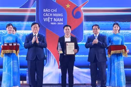 PM Pham Minh Chinh (second from right) and Chairman of the Party Central Committee's Commission for Information, Education and Mass Mobilisation Nguyen Trong Nghia (second from left) present an award to a representative of VietnamPlus reporters at the ceremony on June 21. (Photo: VNA)