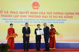 Deputy Prime Minister Nguyen Hoa Binh (second from right) presents the Prime Minister's decision to establish the Da Nang Free Trade Zone on June 22. (Photo: VNA)