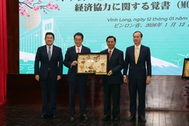 Secretary of the Vinh Long Party Committee Tran Van Lau (second from right) presents a gift to Ehime Governor Tokihiro Nakamura at the MoU signing ceremony on January 12. (Photo: VNA)