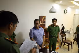 A police officer of Can Tho city reads the decision to launch legal action against Vo Xuan Truong, Chairman and CEO of Mekolor JSC. (Photo published by VNA)