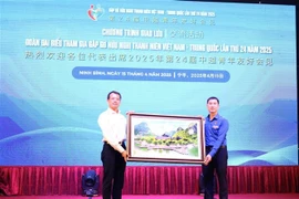Secretary of the Ninh Binh provincial Youth Union Trinh Nhu Lam (right) presents a painting of the Trang An landscape to a representative of the Chinese youth. (Photo: VNA)