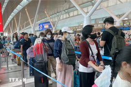 Passengers wait to handle boarding procedures at Tan Son Nhat International Airport. (Photo: VNA)