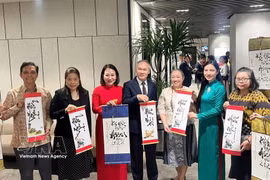 Consuls general of ASEAN countries in Ho Chi Minh City show calligraphy works presented to them at the gathering on August 7. (Photo: VNA)